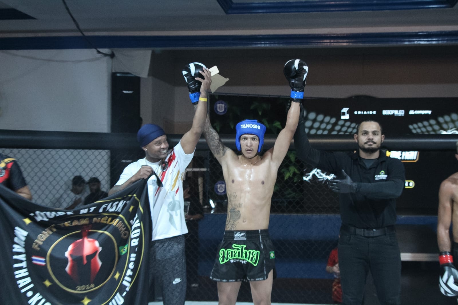 Árbitro levantando o braço do atleta da NT Fight vitorioso no octógono